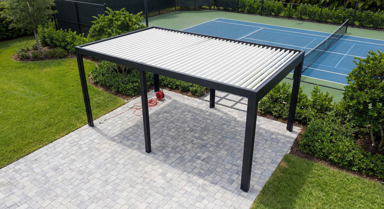 Freestanding louvered roof with white louvers over a paver patio