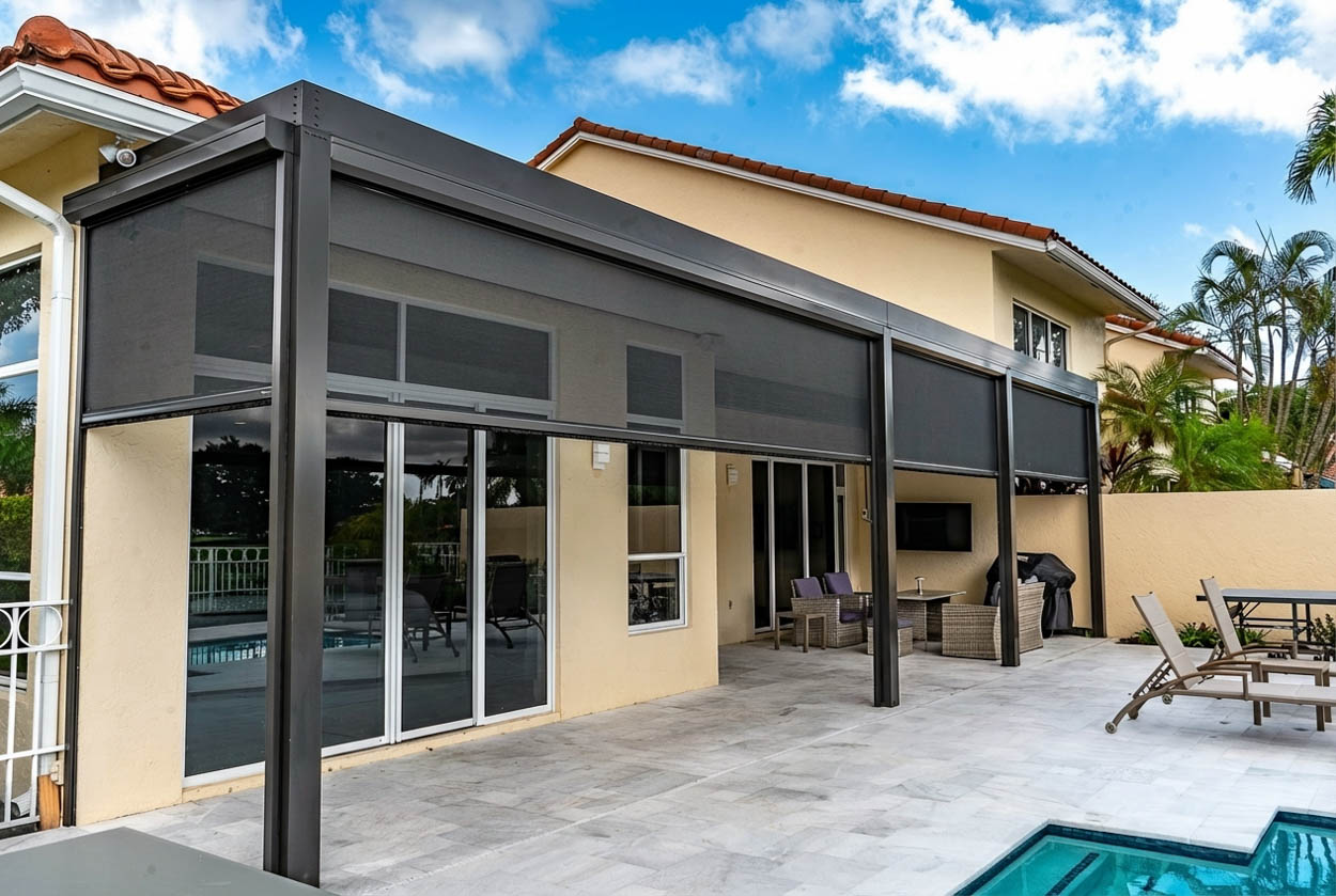 Patio screen enclosure built adjacent to a pool area, creating a protected and comfortable outdoor environment for Florida homes.