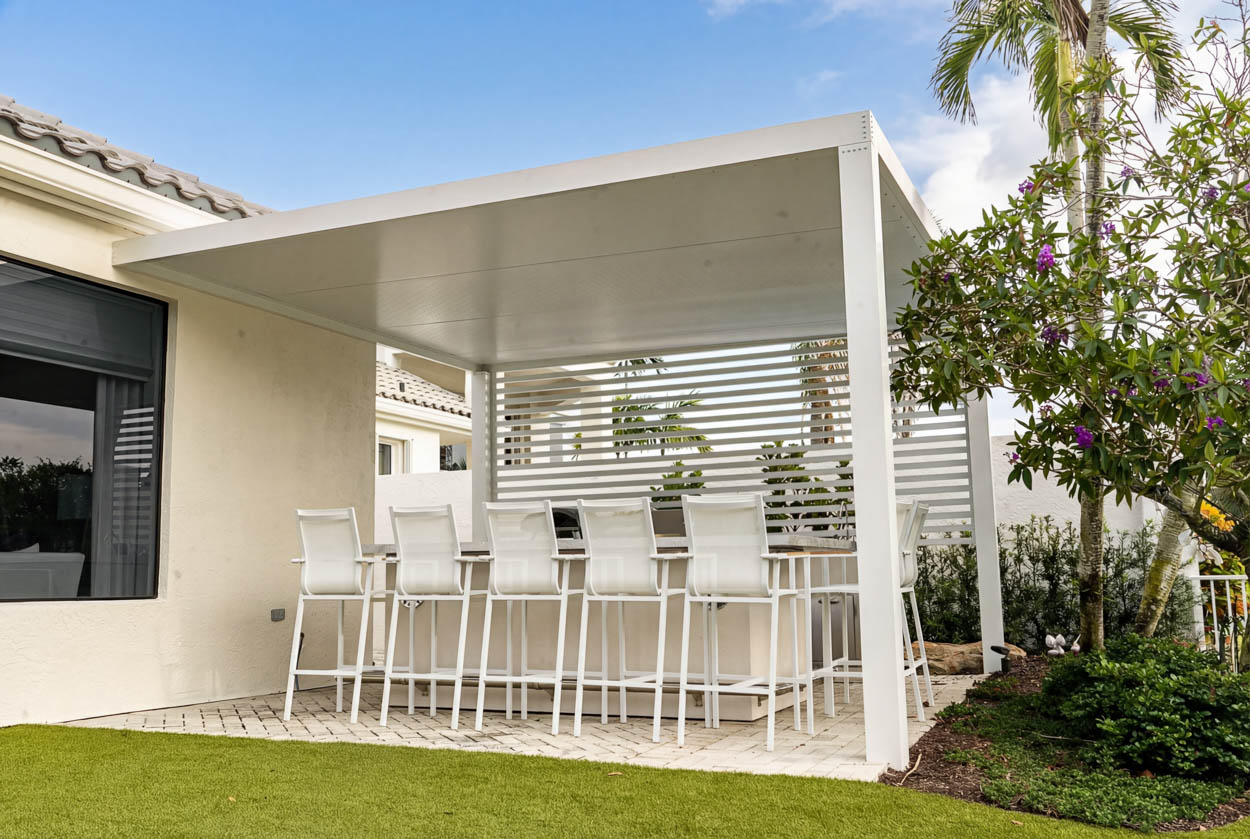 White aluminum modern insulated pergola installation with bar seating by Florida builders, creating functional and stylish outdoor living.