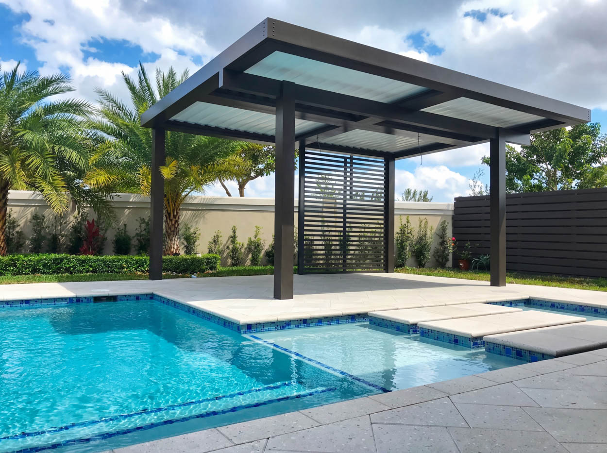 Dark aluminum pergola with a slatted privacy screen beside a pool and spa