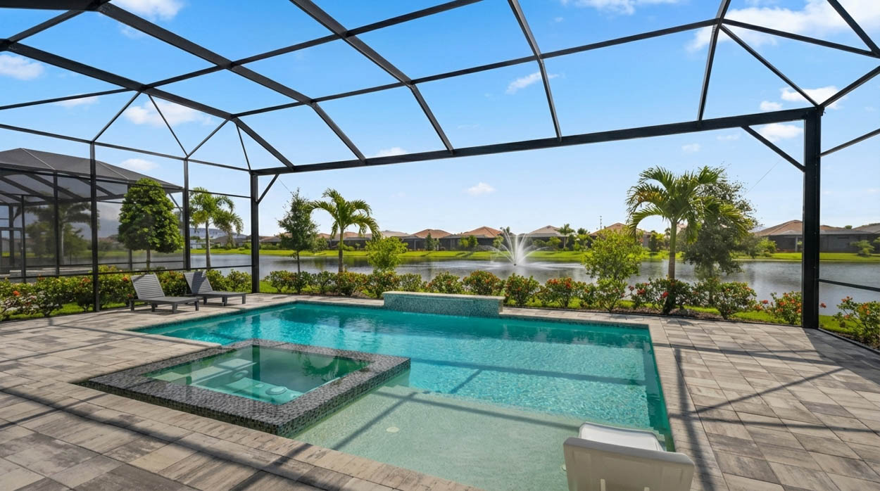 Screen enclosure over a pool and spa with a view of a lake and fountain